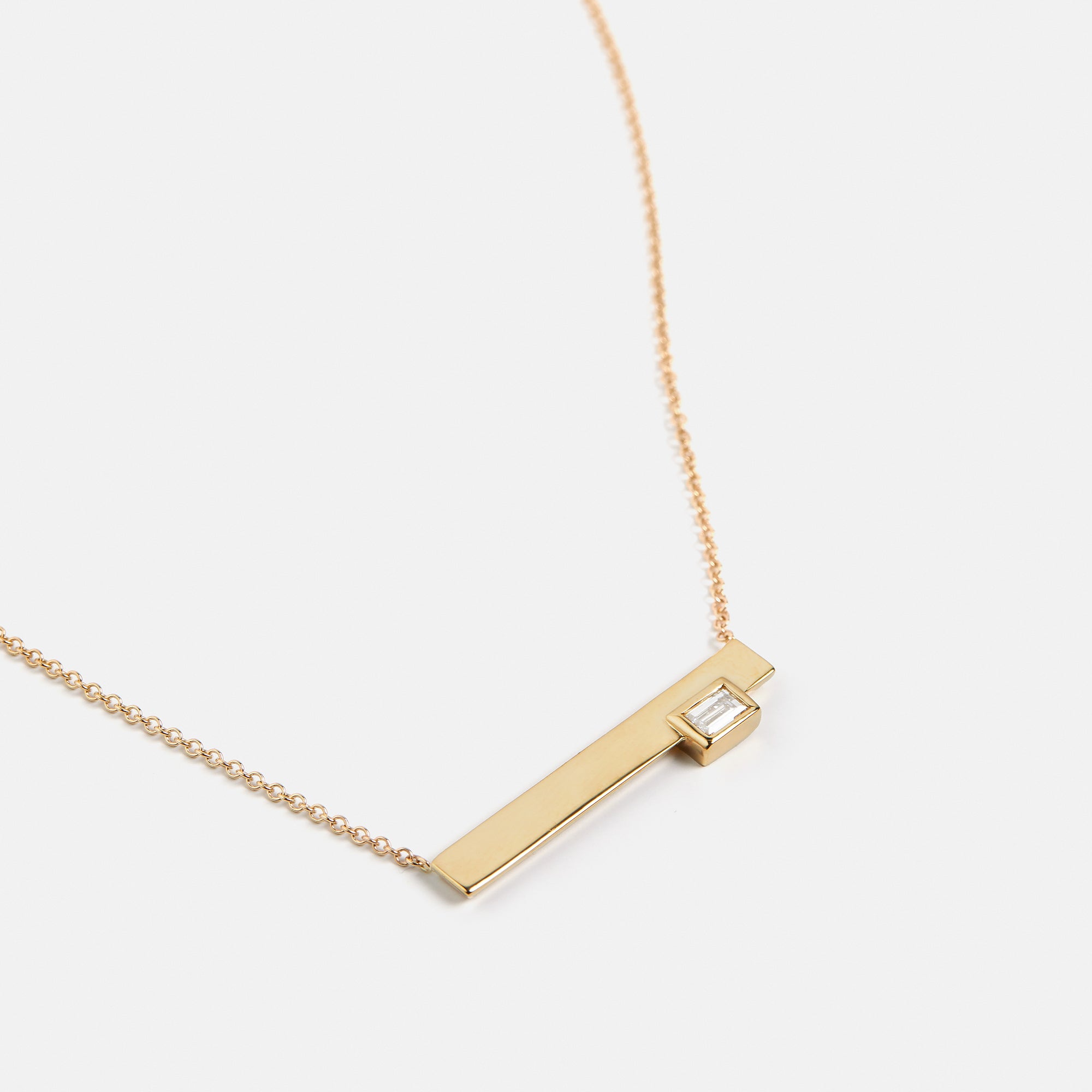 Minimalist necklace with asymmetrical pendant with lab made baguette cut white diamond in 14k gold by SHW best fine jewelry stores in NYC