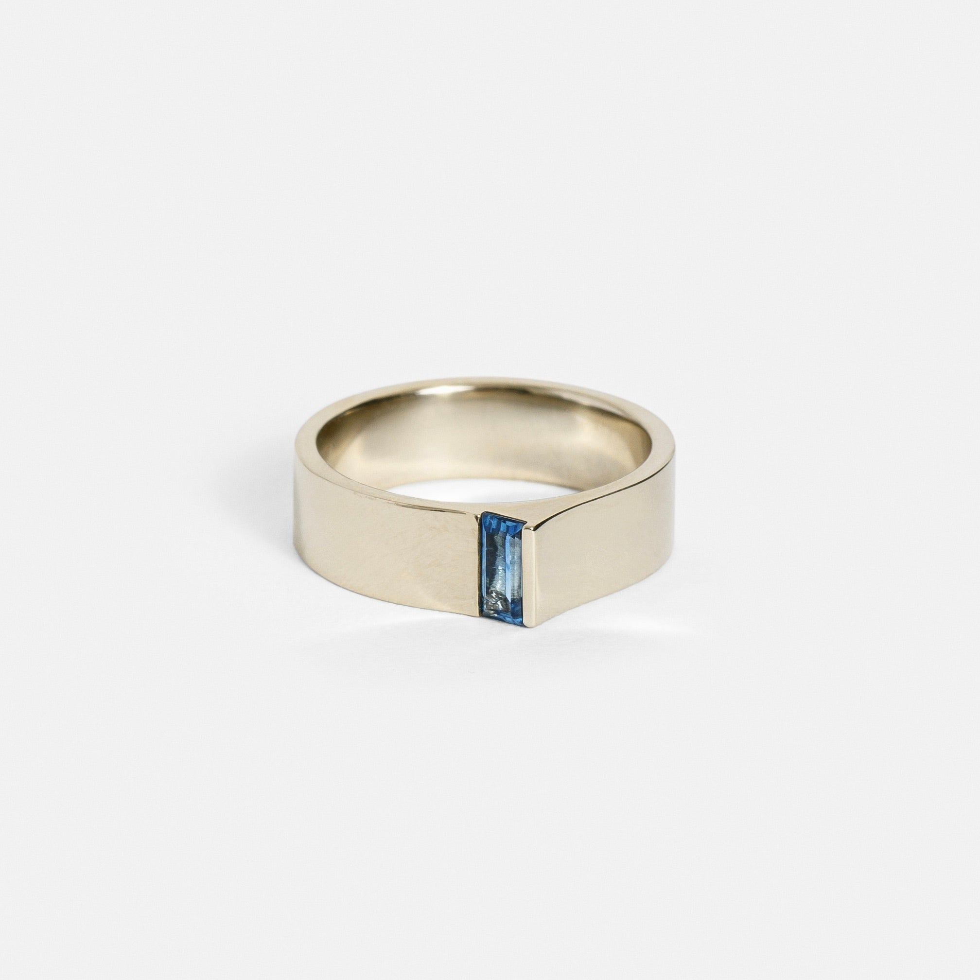 14k white gold 5.5mm flat band with baguette-cut blue sapphire set at the edge