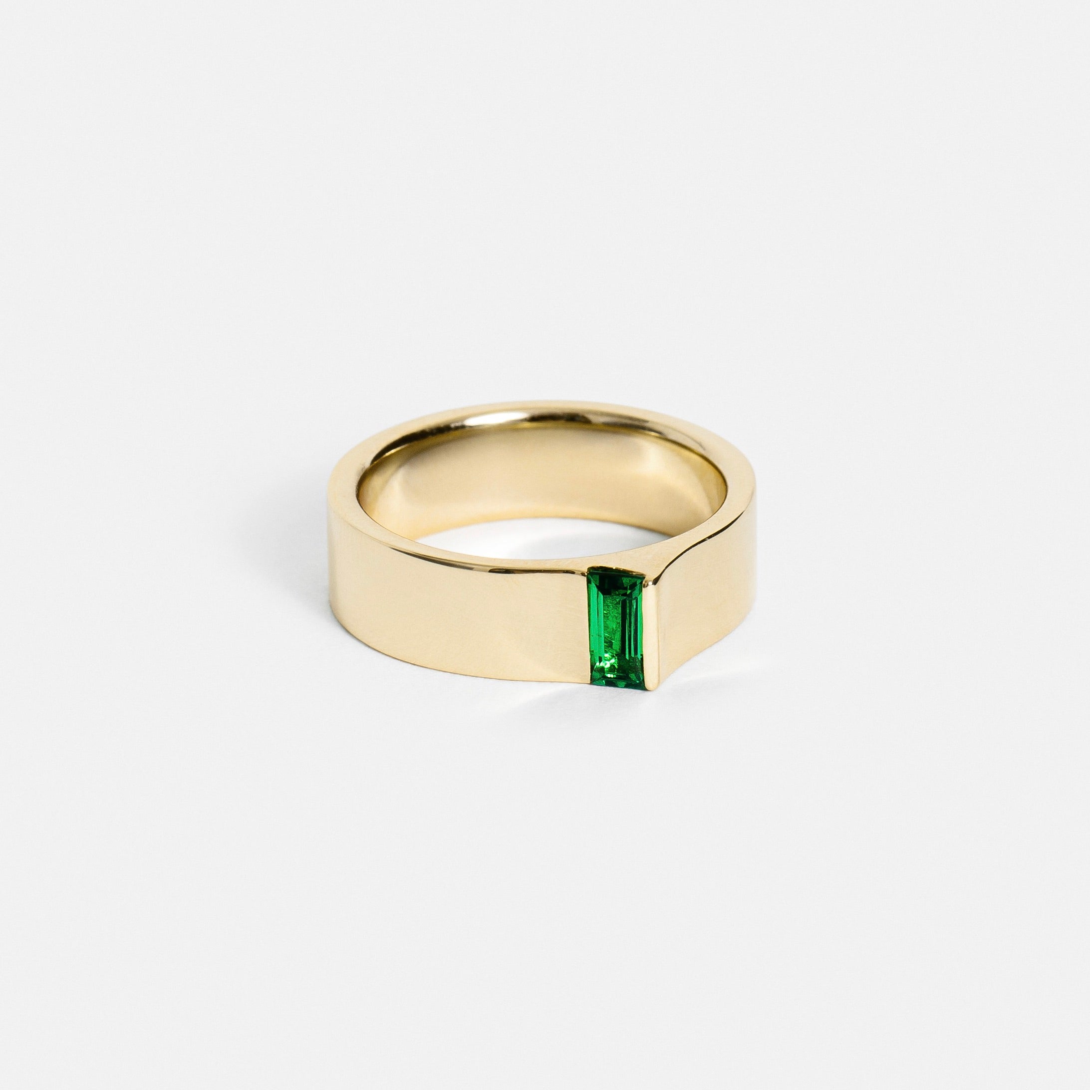 14k yellow gold 5.5mm flat band with baguette-cut green tsavorite set at the edge