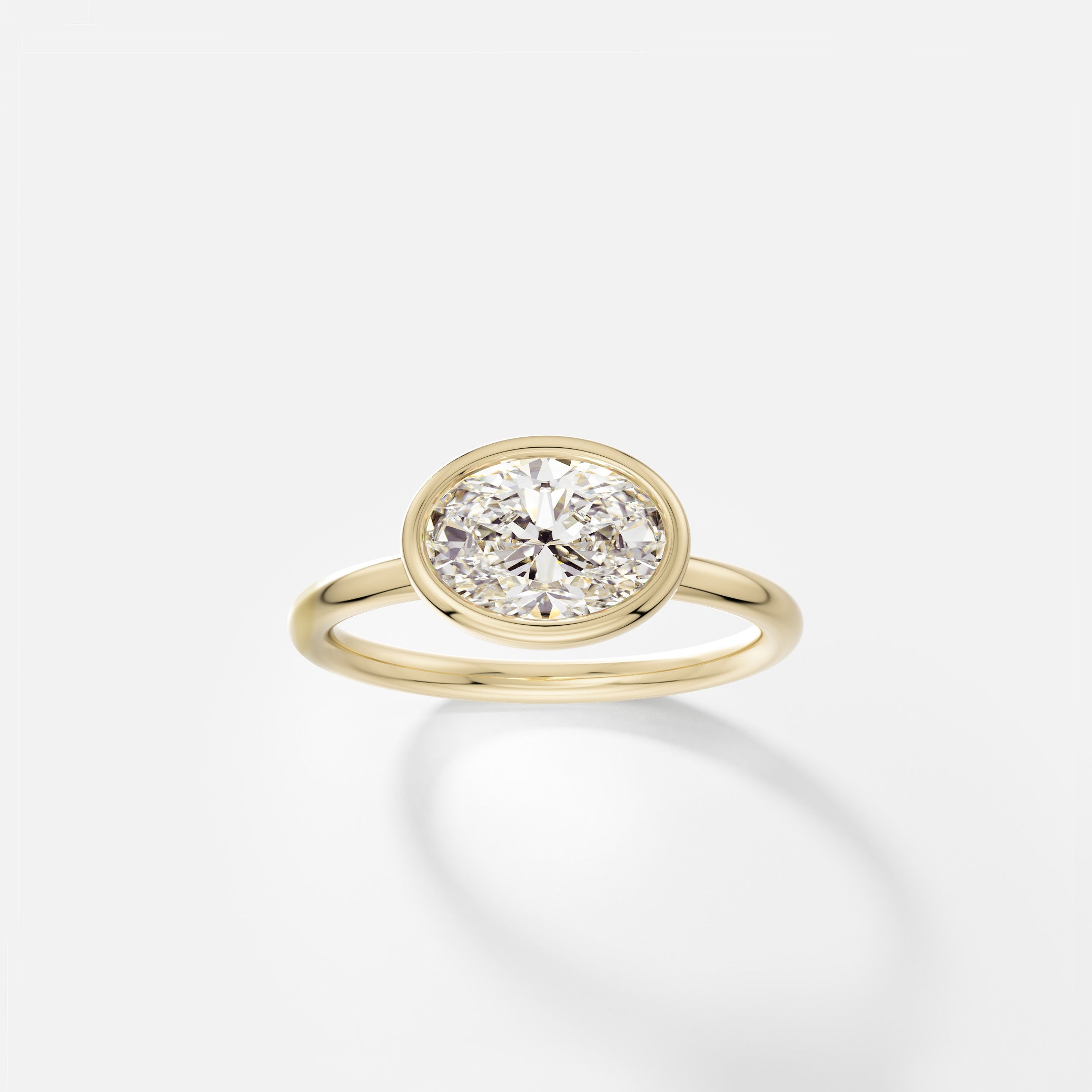 Arti east west oval diamond bezel ring front view in 14k yellow gold