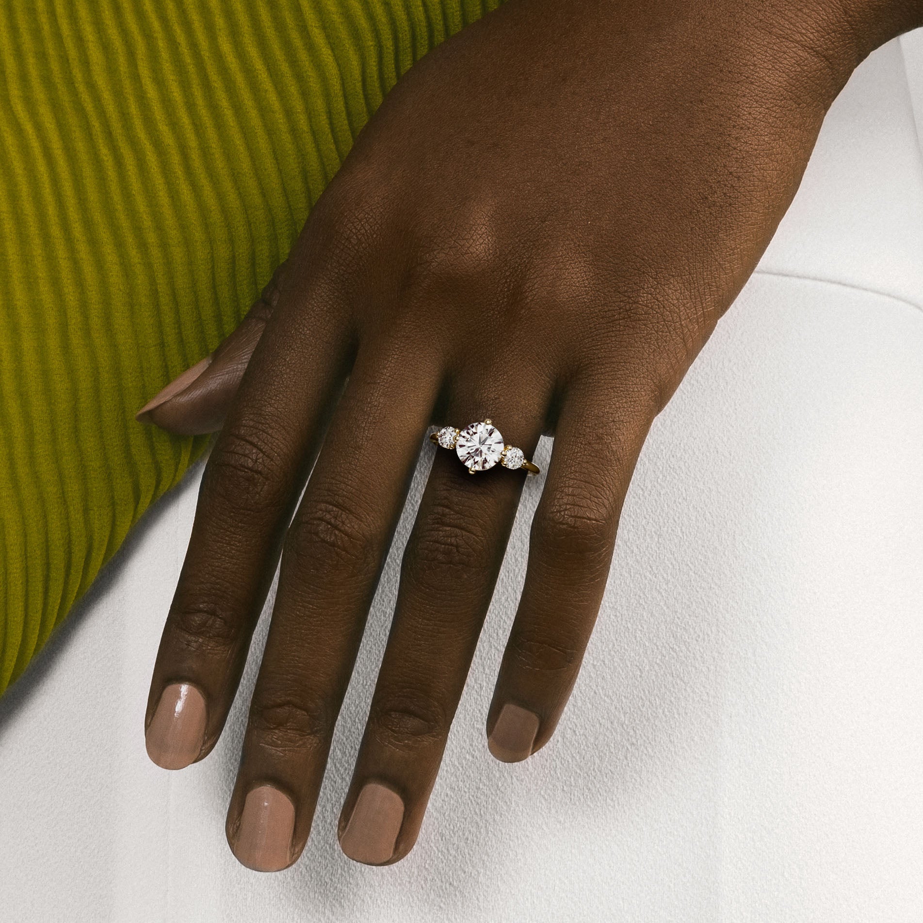 Close view of round brilliant diamond three stone engagement ring with round accent stones on delicate band