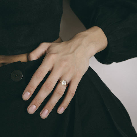 Minimal yellow gold engagement ring with bezel set round brilliant diamond worn on hand