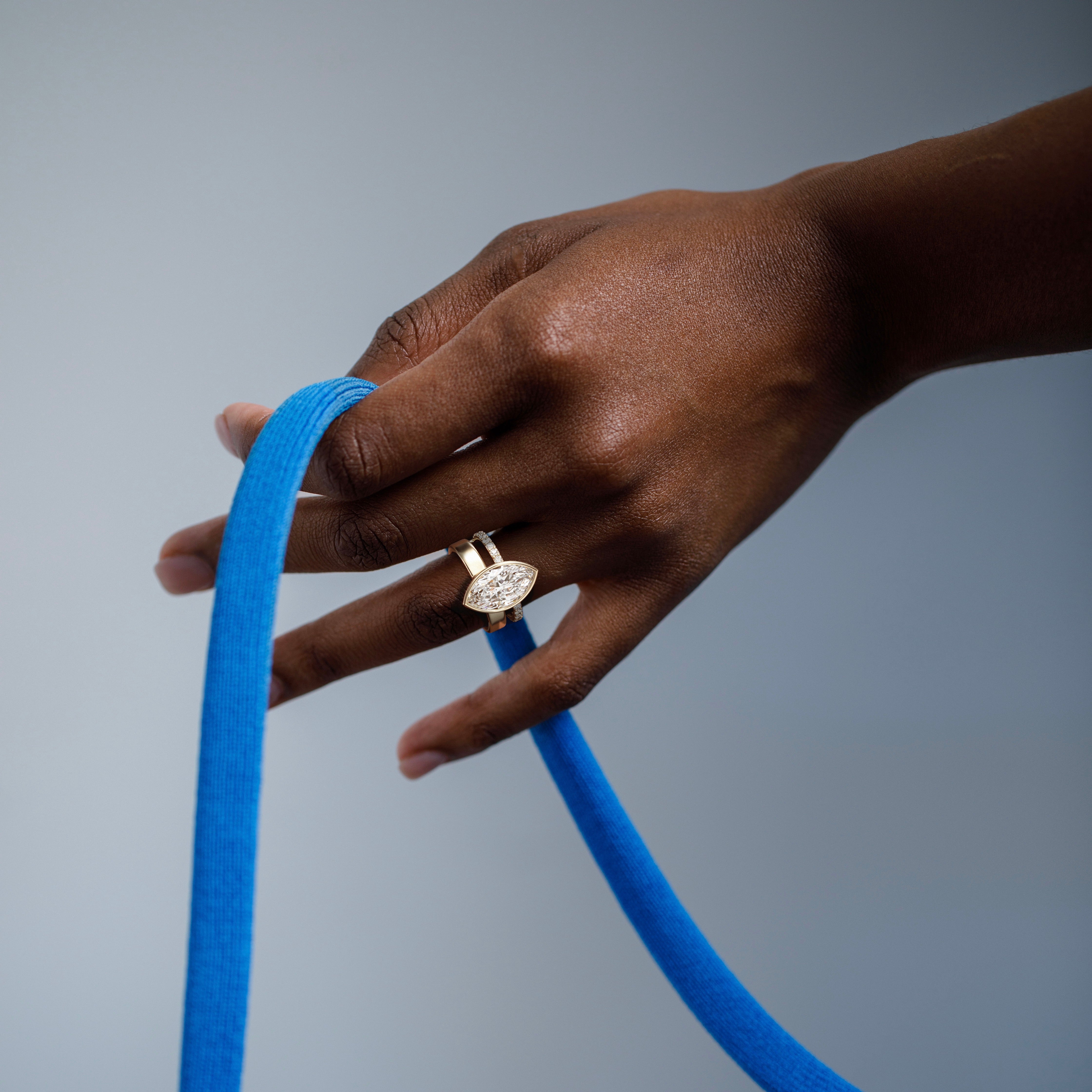 4 carat marquise diamond engagement ring with bezel setting and pavé diamond eternity band worn on hand