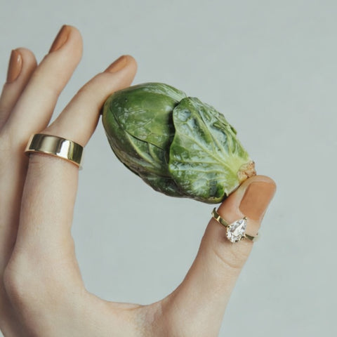 Pear-cut diamond engagement ring worn on hand, featuring a slim gold band and elongated silhouette