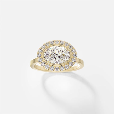 14k yellow gold halo engagement ring with 1.50 carat oval diamond set east west in bezel with pavé diamond halo