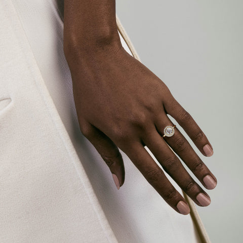 14k yellow gold halo engagement ring with round diamond and pavé halo worn on hand