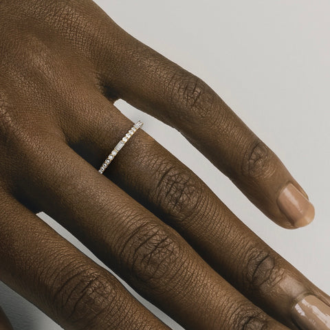 Thin diamond wedding band shown worn in natural light
