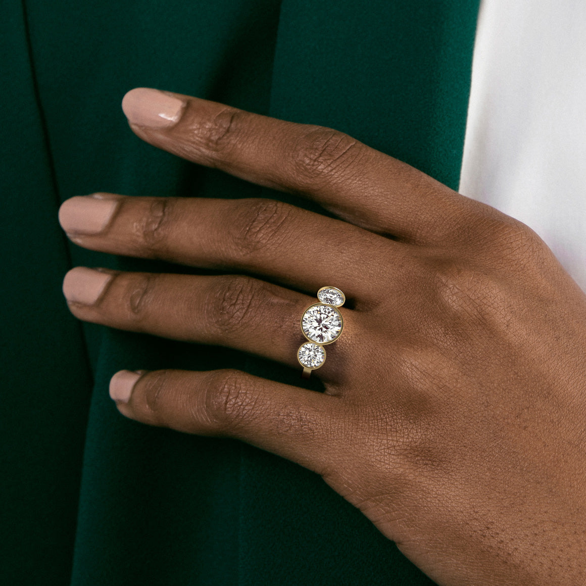 Close view of three stone diamond engagement ring with large center stone and two side diamonds on flat band
