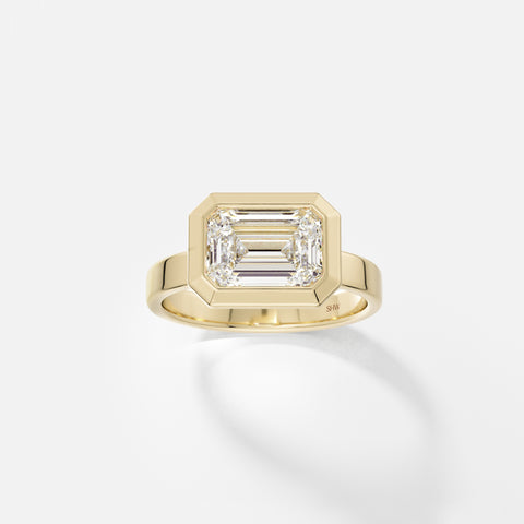 14k yellow gold wide flat band engagement ring with 2.50 carat east west emerald-cut diamond in thick bezel