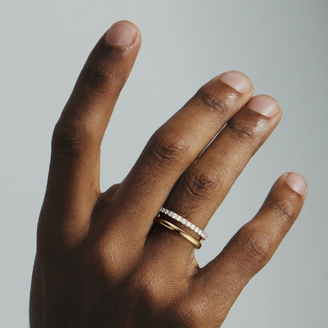Ray2 diamond band worn on hand featuring a pavé diamond band stacked with a polished gold band