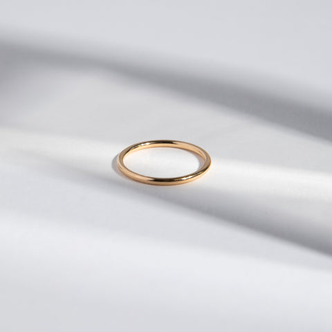 Close view of a 1.5mm round gold wedding band with smooth surface
