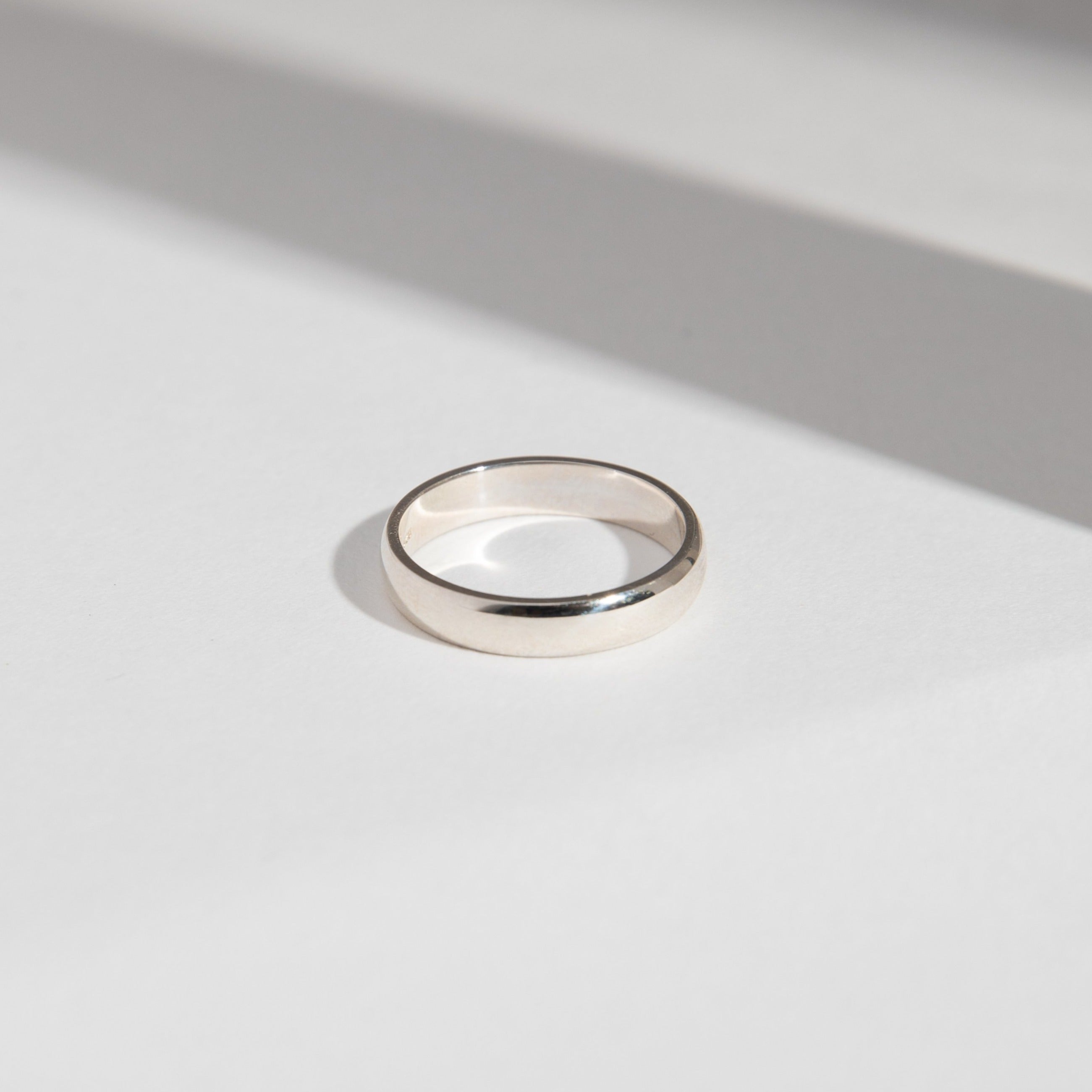 14k white gold 4mm domed wedding band shown in natural light