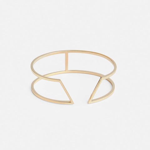 yellow brass bracelet with angular geometric lines and structured modern silhouette