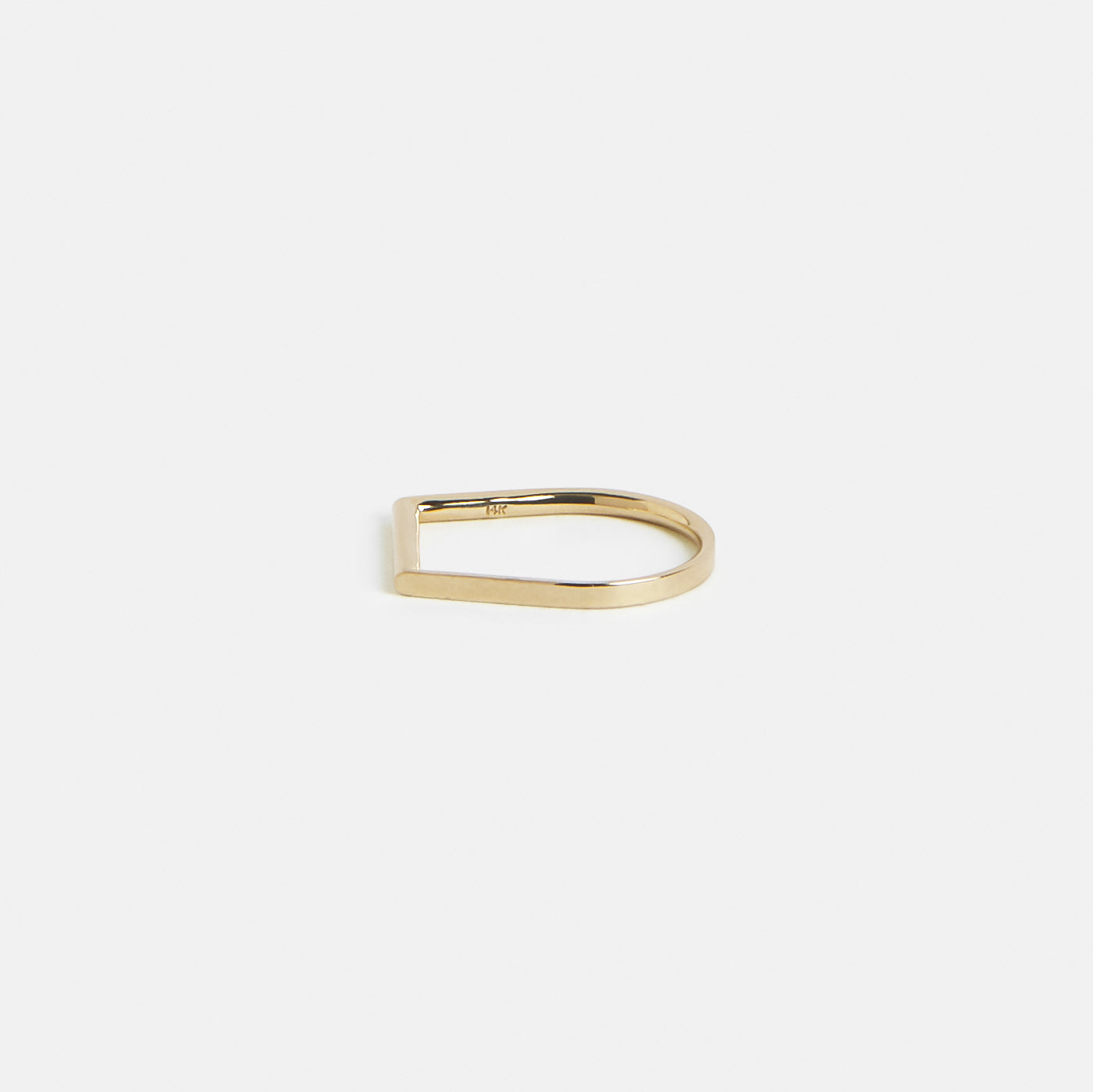 Slim gold wedding band showing curved abstract form