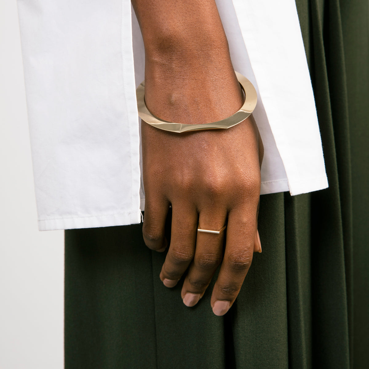 Thin solid gold wedding band worn on hand