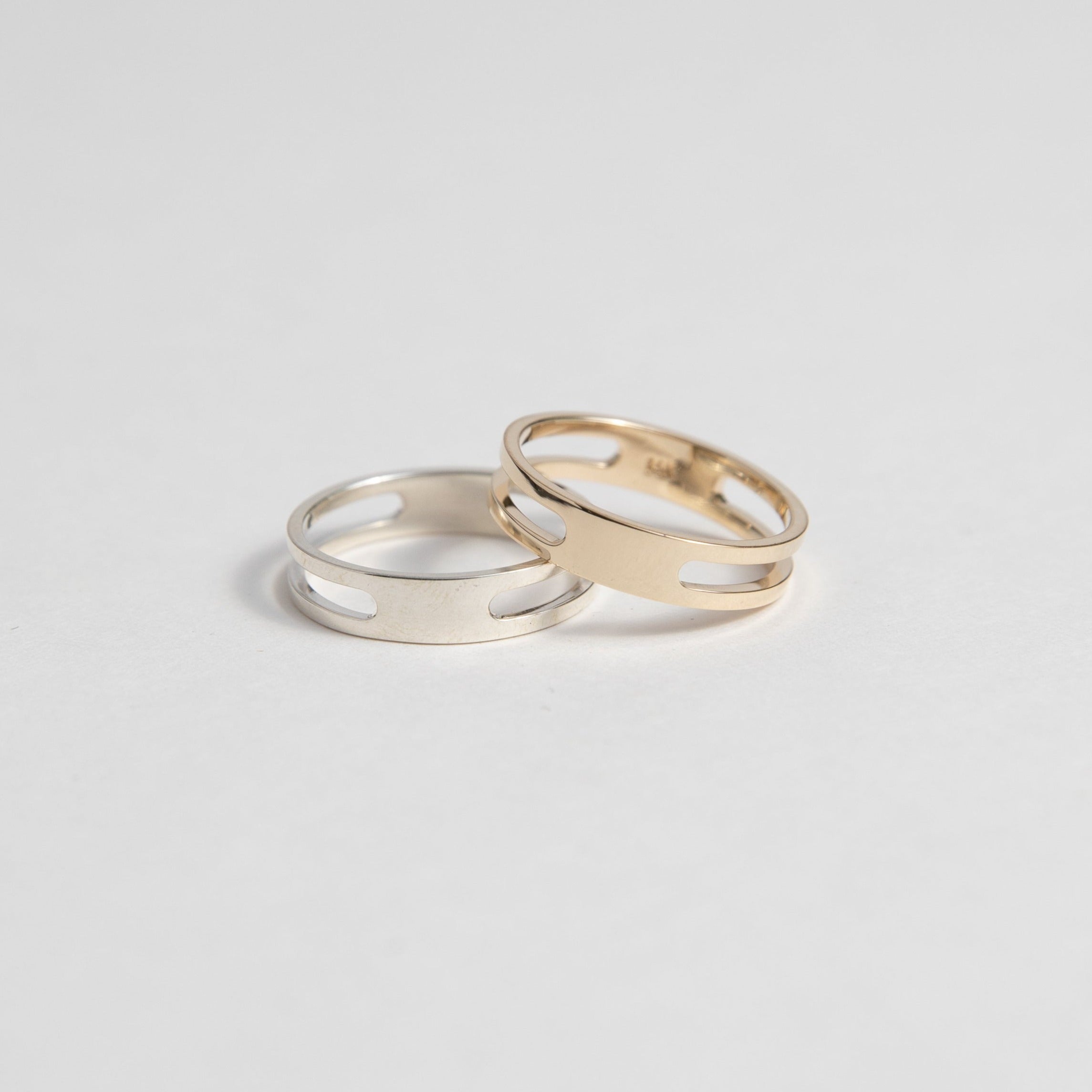 Yellow and white gold double band rings displayed side by side