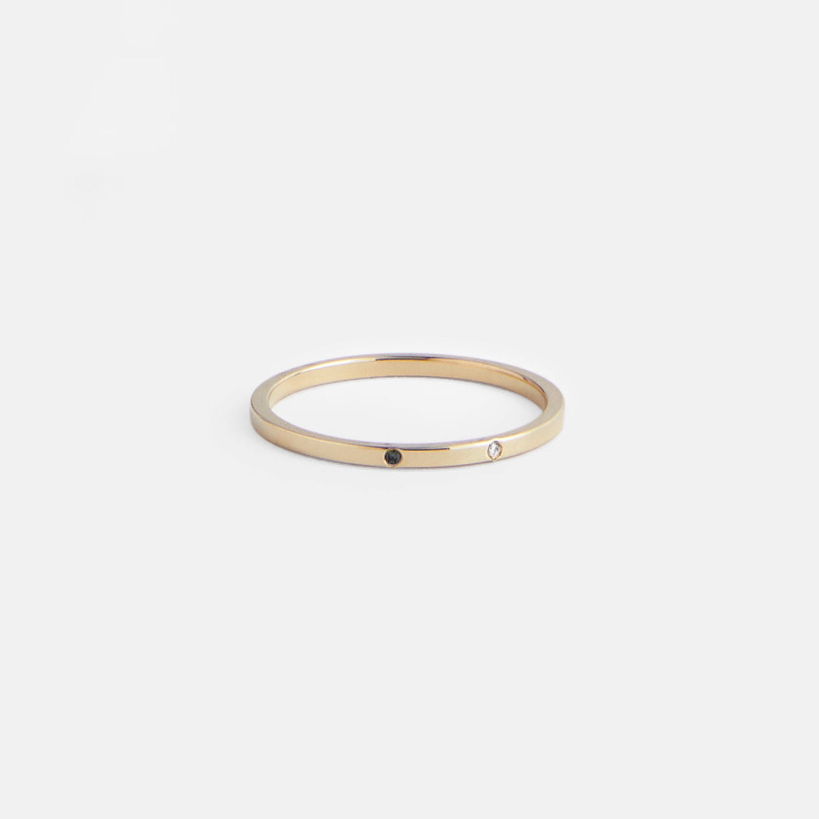 14k yellow gold thin wedding band with one white and one black diamond